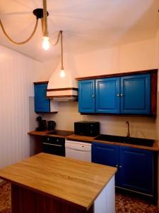 a kitchen with blue cabinets and a counter top at Charmante maison de village Collioure in Collioure