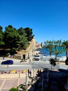 een uitzicht op een straat naast het water met mensen die zitten bij Charmante maison de village Collioure in Collioure