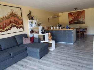 a living room with a couch and a kitchen at instant de tranquillité en Cévennes in Aujac
