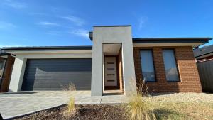 a house with a garage and a blue sky at New 5-BRM Rental House Free Parking Wifi @Melton in Melton South