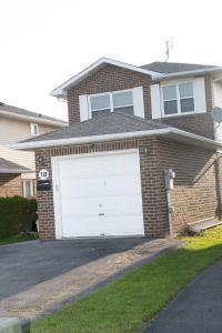 a brick house with a white garage door at Nathan’s Place in Brampton