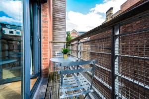 einen kleinen Tisch auf einem Balkon mit Fenster in der Unterkunft Host & Stay - Duke Street Abode in Liverpool