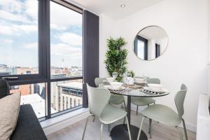 comedor con mesa, sillas y espejo en Host & Stay - The Baltic Penthouse 3 en Liverpool