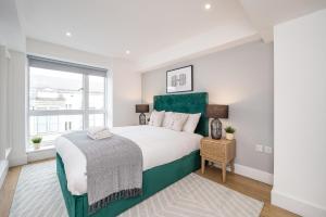 a white bedroom with a large bed and a window at Host & Stay - The Cavern Quarter Apartment in Liverpool