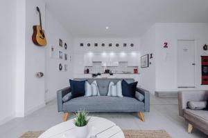 sala de estar con sofá azul y guitarra en Host & Stay - The Musician's Apartment with Grand Piano, en Liverpool