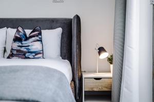 een slaapkamer met een bed en een lamp op een nachtkastje bij Host & Stay - The Musician's Apartment with Grand Piano in Liverpool