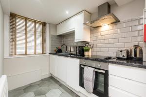a kitchen with white cabinets and a counter top at Host & Stay - City Centre Duplex Apartment in Liverpool