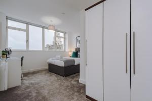 ein Schlafzimmer mit einem Bett und einem großen weißen Schrank in der Unterkunft Host & Stay - Waterfront Penthouse in Liverpool