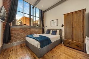 a bedroom with a bed and a brick wall at Host & Stay - Bands Warehouse II in Liverpool
