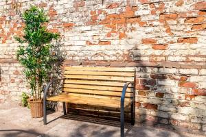 a wooden bench in front of a brick wall at Host & Stay - The Roscoe Carriage House in Liverpool