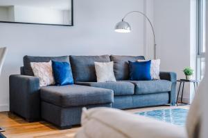 a blue couch and a chair in a living room at Host & Stay - Waterfront View in Liverpool