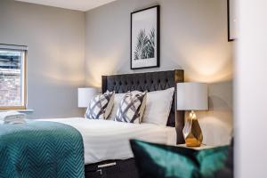 a bedroom with a large bed and a green chair at Host & Stay - Knight St Place in Liverpool