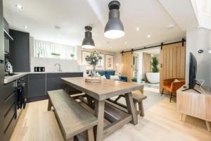 a kitchen and living room with a wooden table and a dining room at Host & Stay - The Georgian Coach House 1 in Liverpool