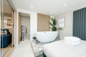 a bathroom with a bath tub and a bed at Host & Stay - The Georgian Coach House 1 in Liverpool