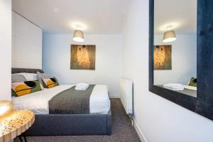 a bedroom with a bed and a mirror at Host & Stay - Preston's Rooftop Apt in Liverpool