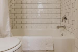 a bathroom with a white tub and a toilet at Modern Mass Ave 1BR Apartment with Kitchen in Indianapolis