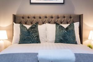 um quarto com uma cama com lençóis brancos e almofadas em Host & Stay - Duke Street Townhouse Apartments em Liverpool