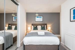 a bedroom with two beds and a mirror at Host & Stay - Duke Street Townhouse Apartments in Liverpool