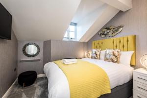 een slaapkamer met een groot bed met een geel hoofdeinde bij Host & Stay - The Pilgrim Coach Houses in Liverpool