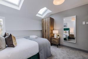 a bedroom with a bed and a mirror at Host & Stay - The Roscoe Coach House in Liverpool