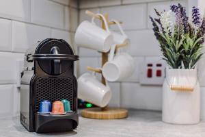 a coffee maker on a counter next to a vase with flowers at Host & Stay - The Roscoe Coach House in Liverpool