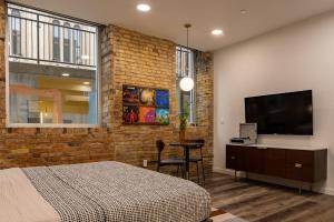 a bedroom with a bed and a flat screen tv at The Finnley Hotel in Grand Rapids