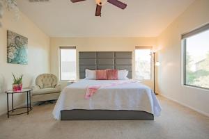 a bedroom with a large bed and a chair at Desert Oasis Amazing Pool Waterfall Firepit Office in Casa Grande