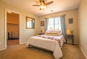 a bedroom with a bed and a ceiling fan at Desert Oasis Amazing Pool Waterfall Firepit Office in Casa Grande