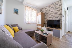 a living room with a couch and a flat screen tv at Apartments Gruda in Cetinje