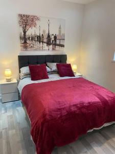 1 dormitorio con 1 cama grande de color rojo y 2 almohadas de color rojo en Lovely City Home, en Edimburgo