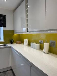 una cocina con encimeras blancas y electrodomésticos blancos en Lovely City Home, en Edimburgo