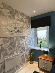 a room with a wall with a fan and a window at Lovely City Home in Edinburgh