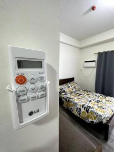 a hotel room with a bed and a remote control at Minimalist studio unit in Davao City