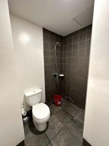 a small bathroom with a toilet and a shower at Minimalist studio unit in Davao City
