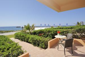 a patio with a table and chairs and the beach at Nanakis Beach Apartments in Stavros