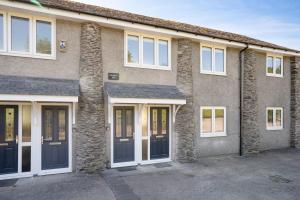 una casa con puertas negras y ventanas blancas en Kentmere Haven - 2 Bedroom - Cycle Storage, en Kendal