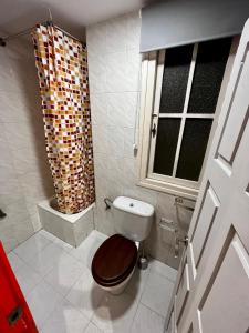 uma casa de banho com um WC com um assento em madeira e uma janela em Loft Villaviciosa em Villaviciosa
