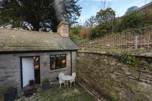 a small stone house with a table and chairs at Romantic rural couples retreat in the stunning village of Crosthwaite, Lyth Valley in Kendal