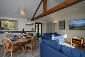 ein Wohnzimmer mit einem blauen Sofa und einem Tisch in der Unterkunft Grasmere Cottage with Stunnng Views by LetMeStay in Ambleside