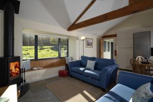 ein Wohnzimmer mit einem blauen Sofa und einem Kamin in der Unterkunft Grasmere Cottage with Stunnng Views by LetMeStay in Ambleside