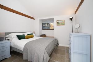 ein weißes Schlafzimmer mit einem Bett und einer Kommode in der Unterkunft Grasmere Cottage with Stunnng Views by LetMeStay in Ambleside