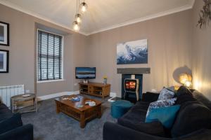ein Wohnzimmer mit einem Sofa und einem Kamin in der Unterkunft Spacious Home with Outstanding Views by LetMeStay in Ambleside