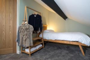 ein Schlafzimmer mit einem Bett und einem Kleid auf einem Regal in der Unterkunft Spacious Home with Outstanding Views by LetMeStay in Ambleside