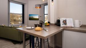 eine Küche mit einem Tisch und einem Sofa in einem Zimmer in der Unterkunft Calm - 1BR - 1BA - Apartment - Central Ambleside in Ambleside