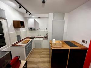 cocina con armarios blancos y encimera de madera en Loft Villaviciosa, en Villaviciosa