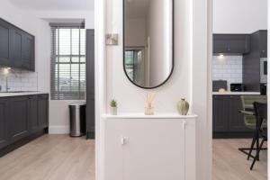 a kitchen with black cabinets and a mirror on the wall at Spacious Apartment in Coniston, by LetMeStay in Coniston