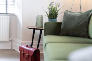 a red suitcase sitting next to a couch with a table at Spacious Apartment in Coniston, by LetMeStay in Coniston