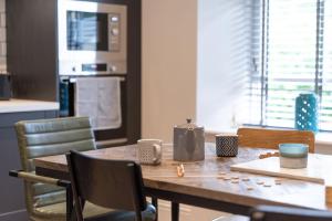 a wooden table with chairs and a kitchen with a counter at Spacious Apartment in Coniston, by LetMeStay in Coniston