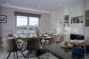 una sala da pranzo con tavolo, sedie e finestra di Brand New - Contemporary - 2 Bedroom - 2 Bathroom - Spacious Apartment - Lake Views ad Ambleside