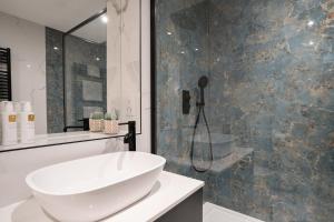 a bathroom with a white sink and a shower at Brand New - Contemporary - 2 Bedroom - 2 Bathroom - Spacious Apartment - Lake Views in Ambleside